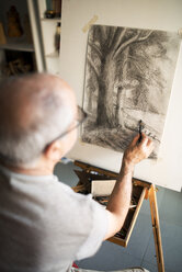 Senior man sketching on canvas at home - CAVF22710
