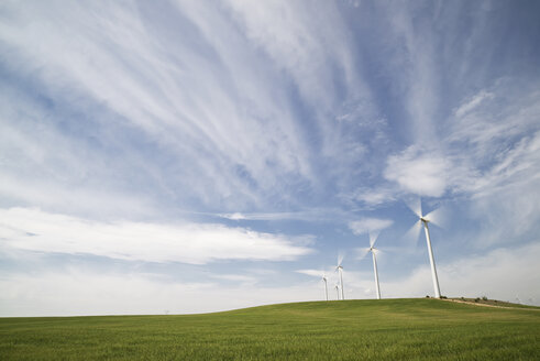 Windkraftanlagen auf einem Feld vor bewölktem Himmel - CAVF22747