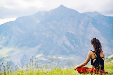 Rückansicht einer Frau beim Yoga gegen Berge - CAVF22751