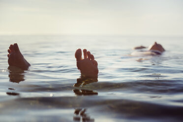 Junge Frau schwimmt mit nackten Füßen auf dem Meer - CAVF22788