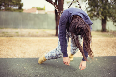 Traurige Frau auf einer Schaukel auf einem Spielplatz liegend - CAVF22798