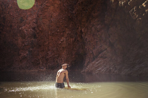 Mann ohne Hemd steht und schreit im See am Berg - CAVF22838