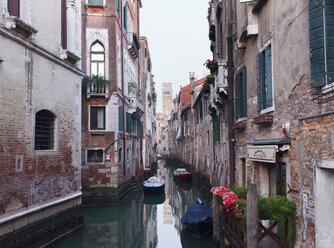 Boats moored at narrow canal amidst residential buildings in city - CAVF22913