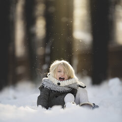 Porträt eines fröhlichen Mädchens, das im Schnee im Park spielt - CAVF22956