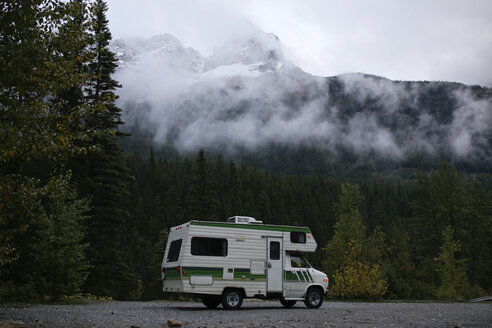 Wohnmobil auf der Straße gegen Bäume und Berge bei nebligem Wetter - CAVF23022