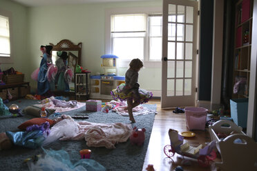 Mädchen tanzt in unordentlichem Zimmer zu Hause - CAVF23104