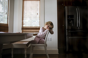 Portrait of bored girl sitting on chair at home - CAVF23130