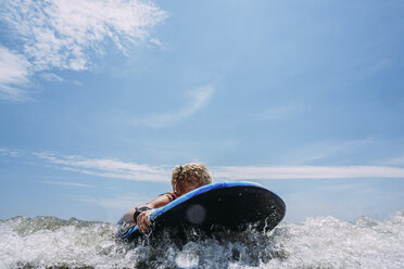 Unbekümmertes Mädchen surft auf dem Meer gegen den Himmel - CAVF23198