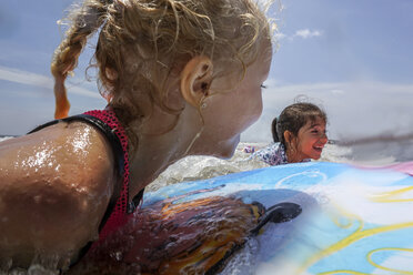 Happy female friends surfing on sea against sky - CAVF23199