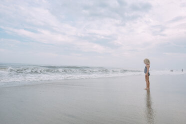 Mädchen in voller Länge am Cape May Beach gegen bewölkten Himmel stehend - CAVF23201