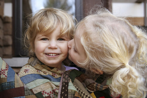 Porträt eines glücklichen Mädchens, während die Schwester sie küsst - CAVF23216