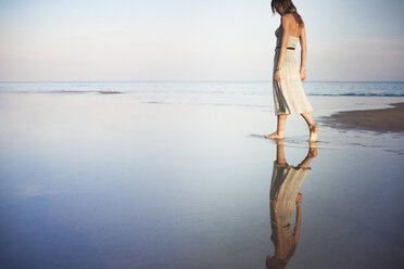 Frau spaziert am Strand gegen den Himmel - CAVF23274