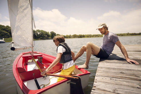 Vater und Sohn mit Boot im See gegen den Himmel - CAVF23287