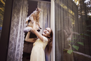 Mädchen spielt mit Katze auf Veranda - CAVF23300