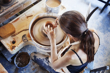 Directly above shot of woman making clay pots at workshop - CAVF23314