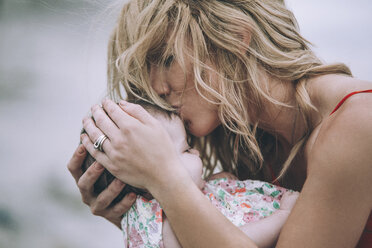 Woman with blond hair kissing daughter - CAVF23329