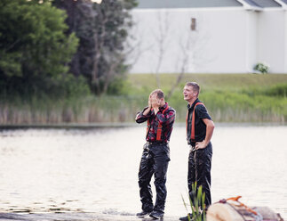 Wet people standing at riverbank - CAVF23340