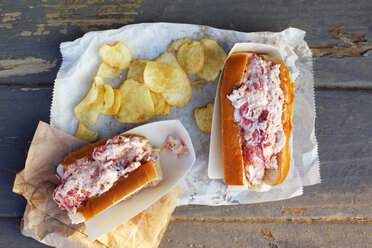 Draufsicht auf Sandwiches mit Kartoffelchips auf einem Holztisch - CAVF23346