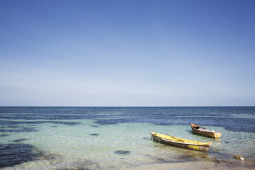 Boats moored on sea against clear blue sky - CAVF23356