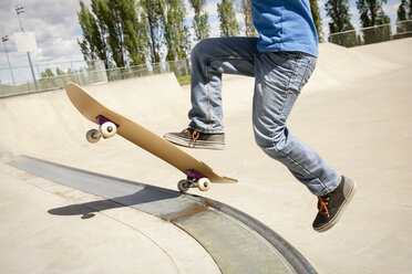 Niedriger Ausschnitt eines Jungen, der auf einer Rampe Skateboard fährt - CAVF23418