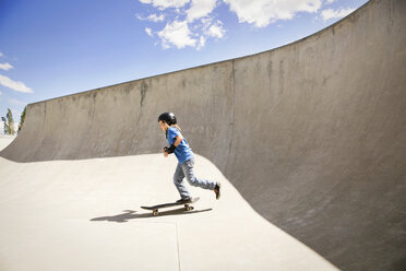 Seitenansicht eines Jungen, der auf einer Rampe Skateboard fährt - CAVF23423