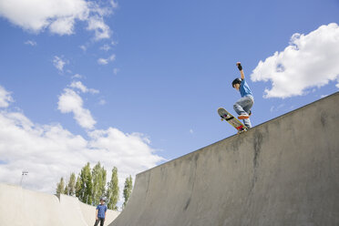 Niedriger Blickwinkel des Jungen Skateboarding auf Rampe gegen blauen Himmel - CAVF23425
