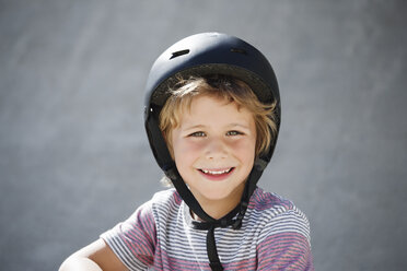Porträt eines glücklichen Jungen im Skateboardpark - CAVF23431