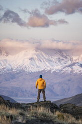 Rückansicht eines Wanderers mit Blick auf schneebedeckte Berge - CAVF23478