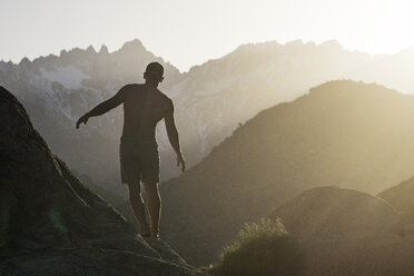 Rückansicht eines Wanderers, der auf einem Berg gegen den Morgenhimmel balanciert - CAVF23479
