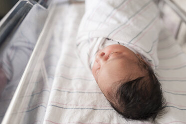 High angle view of sleeping newborn baby in hospital crib - CAVF23523