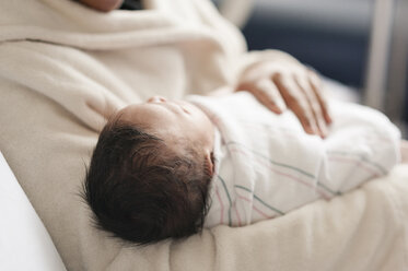 Midsection of mother carrying newborn baby in hospital - CAVF23524