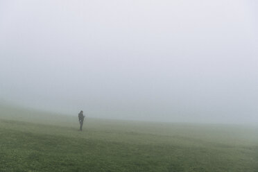 Wanderer auf dem Feld stehend bei nebligem Wetter - CAVF23609