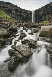 Idyllischer Blick auf einen durch Felsen fließenden Bach gegen einen Wasserfall - CAVF23622