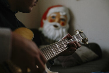 Ausgeschnittenes Bild eines Mannes, der zu Hause Gitarre spielt - CAVF23653