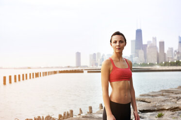 An athletic woman poses while running with a blue sports bra and