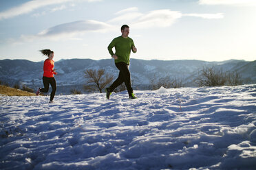 Paar joggt auf Schneefeld gegen Himmel - CAVF23852