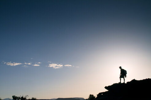 Silhouette eines auf einem Berg stehenden Mannes vor dem Himmel - CAVF23862