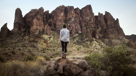 Rückansicht eines Teenagers, der auf einem Felsen vor einem Berg steht - CAVF23928
