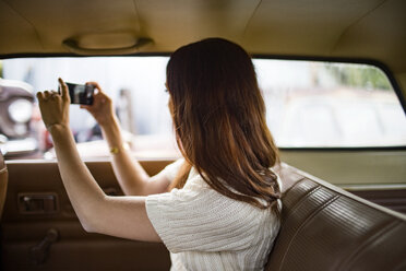 Teenager fotografiert mit Smartphone im Auto - CAVF23932