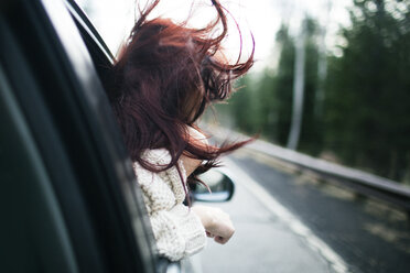Teenager genießt den Wind und späht durch das Autofenster - CAVF23939