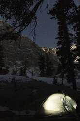 Tent on field against snowcapped mountains at night - CAVF24015