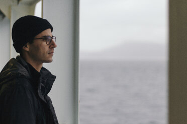 Thoughtful man looking away while standing in cruise ship - CAVF24018