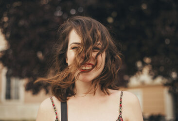 Portrait of happy young woman with tousled hair outdoors - CAVF24034