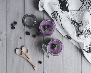 Overhead view of blueberry smoothies by textile on table - CAVF24225