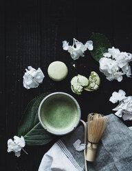 Overhead view of matcha tea with macaroons and hydrangeas on table - CAVF24236