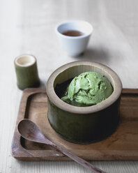 Nahaufnahme von Matcha-Tee-Eis, serviert in Bambus mit Löffel auf einem Serviertablett - CAVF24272