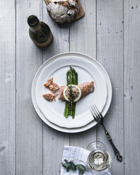 Overhead view of garnished fish served in plate with drink on table - CAVF24276