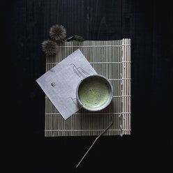 Overhead view of matcha tea in bowl on place mat - CAVF24307