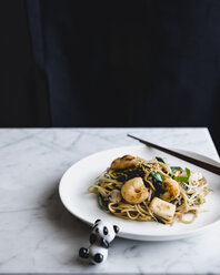 Noodles and prawns served in plate with panda toy on table - CAVF24322