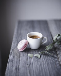 Nahaufnahme von rosa Makrone und Kaffeetasse auf Holztisch - CAVF24351